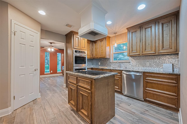 5942 Pebble Springs Dr, Houston, TX 77066 - kitchen featuring appliances with stainless steel finishes, dark stone countertops, decorative backsplash, light wood-style flooring, and recessed lighting