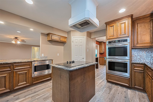 5942 Pebble Springs Dr, Houston, TX 77066 - kitchen with stainless steel appliances, dark stone countertops, light wood-style floors, recessed lighting, and ceiling fan