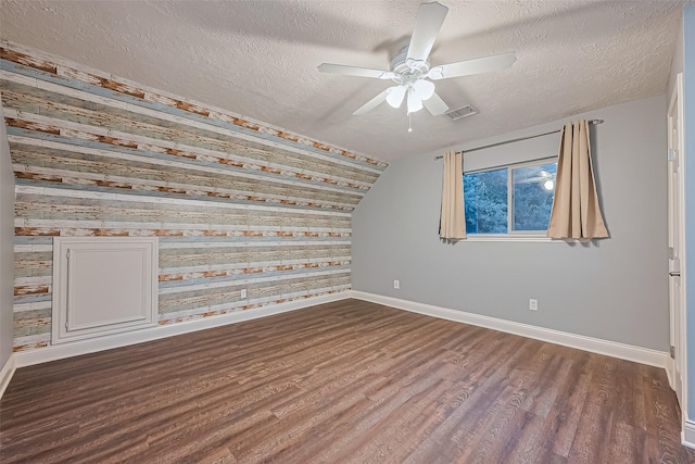 5942 Pebble Springs Dr, Houston, TX 77066 - spare room featuring wood finished floors, a textured ceiling, a ceiling fan, lofted ceiling, and wooden walls