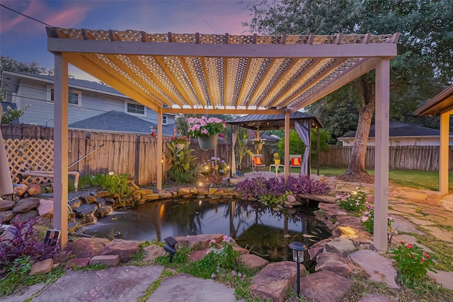 5942 Pebble Springs Dr, Houston, TX 77066 - patio terrace at dusk with a pergola, a garden pond, and a fenced backyard