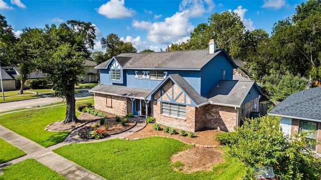 1403 Maygrove Dr, Sugar Land, TX 77498 - tudor home with brick siding, a shingled roof, a front lawn, and a chimney