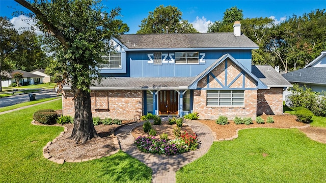 1403 Maygrove Dr, Sugar Land, TX 77498 - view of front of house featuring a front yard, brick siding, a chimney, and a shingled roof