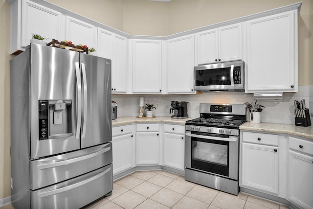 21006 Indigo Field Ln, Richmond, TX 77407 - kitchen featuring appliances with stainless steel finishes, tasteful backsplash, white cabinets, and light tile patterned floors