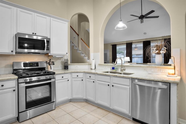 21006 Indigo Field Ln, Richmond, TX 77407 - kitchen with stainless steel appliances, tasteful backsplash, ceiling fan, white cabinets, and light stone counters
