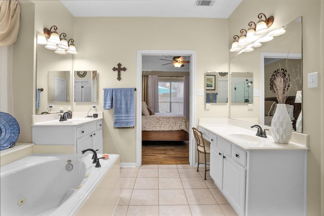 21006 Indigo Field Ln, Richmond, TX 77407 - full bathroom featuring connected bathroom, two vanities, a jetted tub, and tile patterned flooring