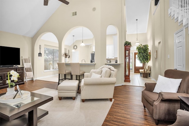 21006 Indigo Field Ln, Richmond, TX 77407 - living room featuring high vaulted ceiling, a ceiling fan, dark wood-style flooring, and arched walkways