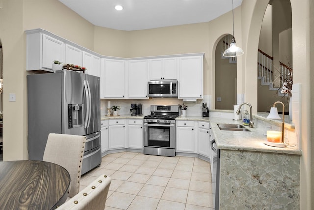21006 Indigo Field Ln, Richmond, TX 77407 - kitchen featuring stainless steel appliances, light tile patterned flooring, white cabinets, and pendant lighting