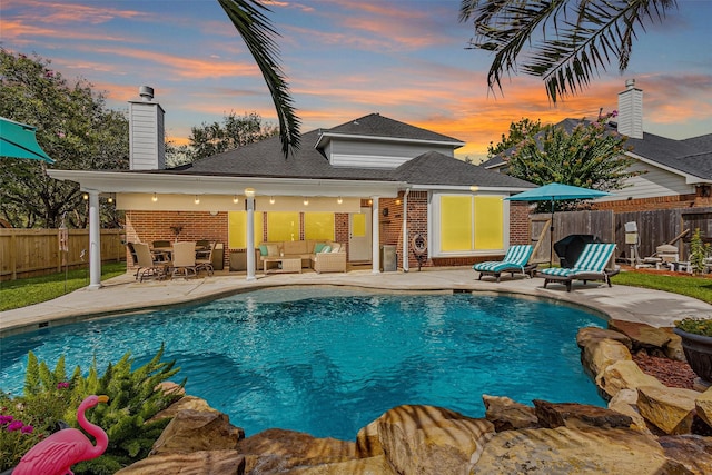 21006 Indigo Field Ln, Richmond, TX 77407 - pool at dusk with an outdoor hangout area, a patio area, an outdoor structure, and a storage structure