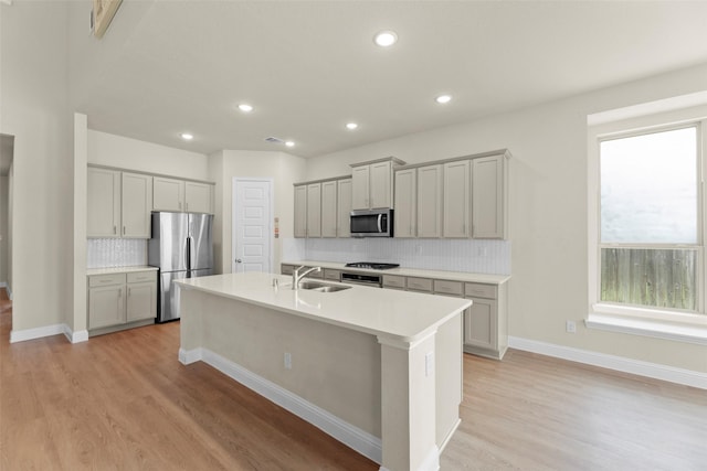 6322 Cambrai Wood Ln, Katy, TX 77493 - kitchen featuring appliances with stainless steel finishes, gray cabinets, light wood finished floors, a center island with sink, and recessed lighting