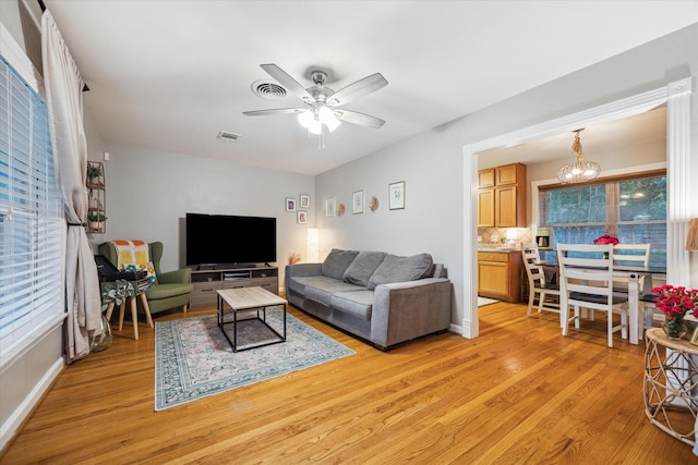 1130 W 30th St, Houston, TX 77018 - living area with light wood-type flooring, a ceiling fan, and a chandelier