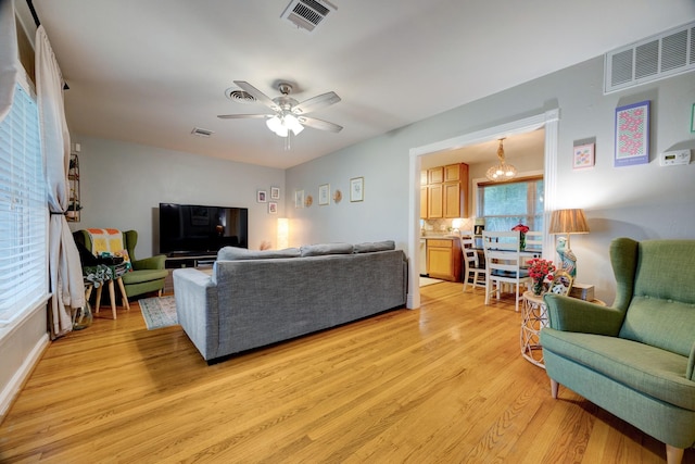 1130 W 30th St, Houston, TX 77018 - living room with light wood-style floors, a ceiling fan, and a chandelier