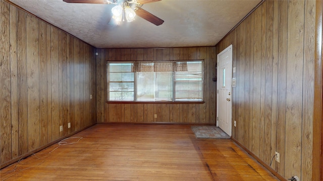 6619 Heron Dr, Houston, TX 77087 - empty room featuring light wood-type flooring, a ceiling fan, and wood walls