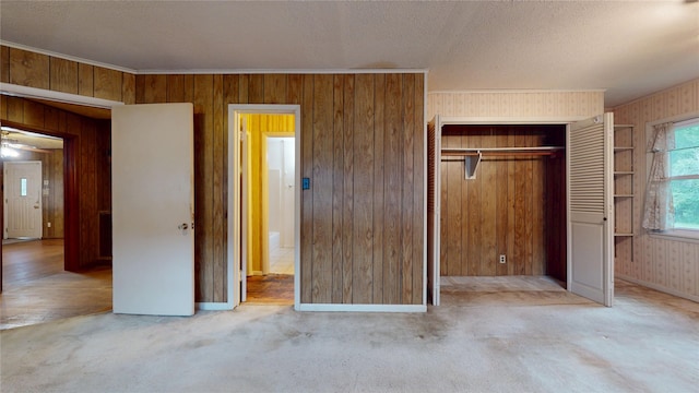 6619 Heron Dr, Houston, TX 77087 - unfurnished bedroom with wood walls, a closet, light carpet, crown molding, and a textured ceiling