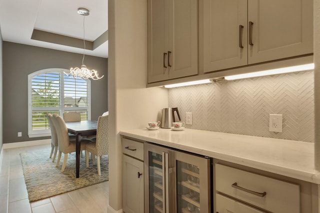 19019 Dappled Mare Cir, Tomball, TX 77377 - indoor dry bar featuring wine cooler, decorative backsplash, a raised ceiling, a chandelier, and decorative light fixtures