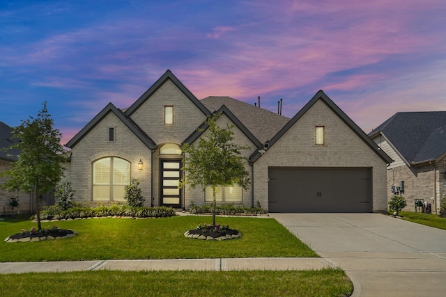 19019 Dappled Mare Cir, Tomball, TX 77377 - french country inspired facade featuring driveway, a yard, brick siding, and an attached garage