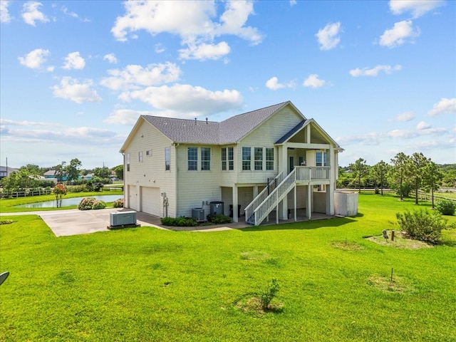 2250 Broadway St, San Leon, TX 77539 - back of house with a garage, concrete driveway, a water view, stairway, and a yard