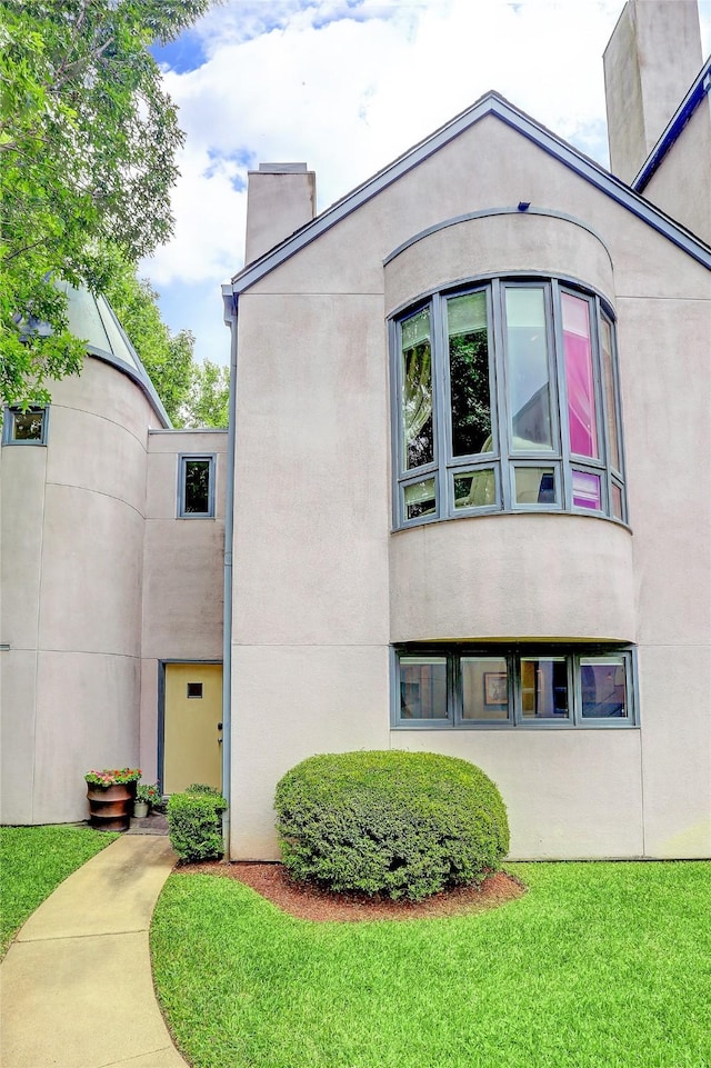 1395 Arlington St Unit 1395, Houston, TX 77008 - view of side of property with a chimney, stucco siding, and a yard