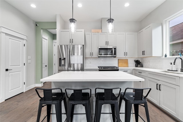 4510 Vernon St, Houston, TX 77020 - kitchen with appliances with stainless steel finishes, backsplash, a kitchen breakfast bar, a kitchen island, and recessed lighting