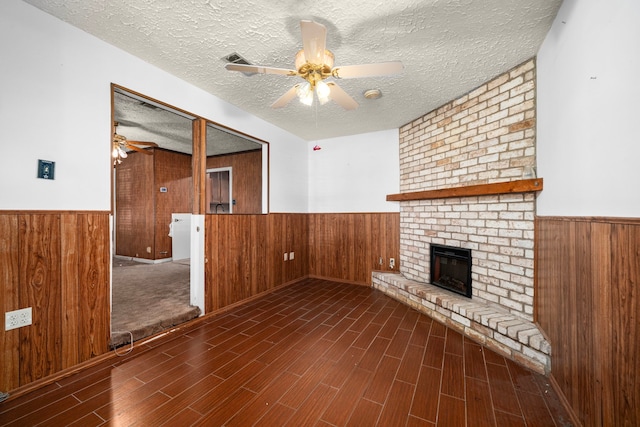 56 Wellford St, Houston, TX 77022 - unfurnished living room featuring wooden walls, wainscoting, ceiling fan, a fireplace, and wood finished floors