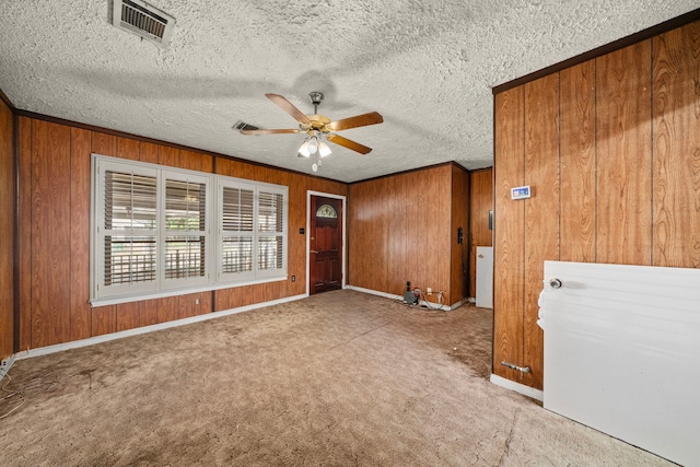 56 Wellford St, Houston, TX 77022 - carpeted spare room featuring ceiling fan, wooden walls, crown molding, and a textured ceiling