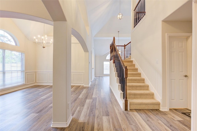 22934 Cove Timbers Ct, Tomball, TX 77375 - entrance foyer featuring arched walkways, a chandelier, high vaulted ceiling, wood finished floors, and stairway