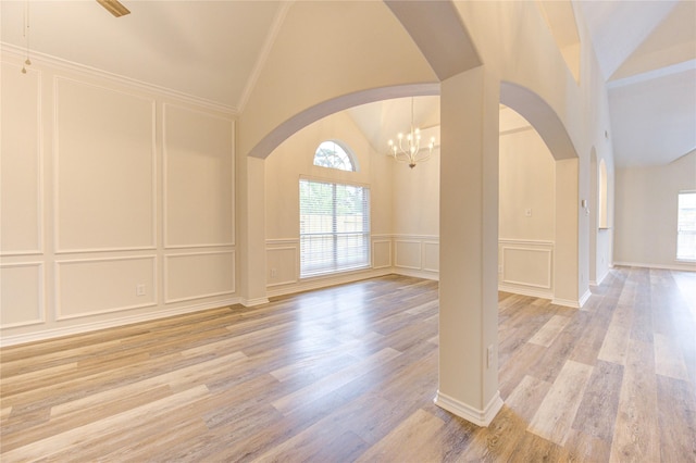 22934 Cove Timbers Ct, Tomball, TX 77375 - spare room with a decorative wall, plenty of natural light, light wood-style flooring, arched walkways, and a chandelier