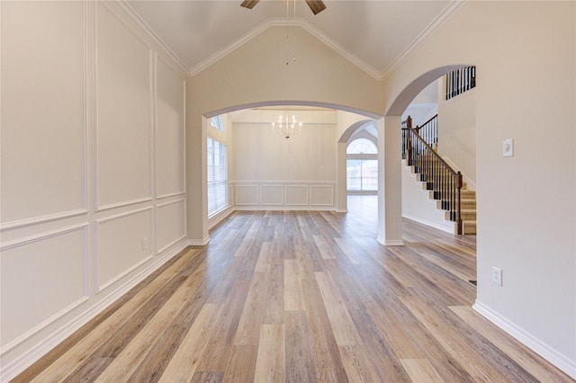 22934 Cove Timbers Ct, Tomball, TX 77375 - foyer entrance with arched walkways, light wood-style floors, a decorative wall, a ceiling fan, and vaulted ceiling
