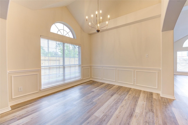 22934 Cove Timbers Ct, Tomball, TX 77375 - spare room with a chandelier, wood finished floors, a decorative wall, wainscoting, and high vaulted ceiling