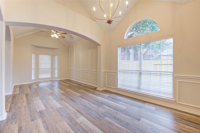 22934 Cove Timbers Ct, Tomball, TX 77375 - unfurnished room featuring arched walkways, ceiling fan, wood finished floors, a chandelier, and a wainscoted wall
