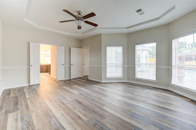 22934 Cove Timbers Ct, Tomball, TX 77375 - unfurnished room featuring a raised ceiling, light wood-style floors, and a ceiling fan