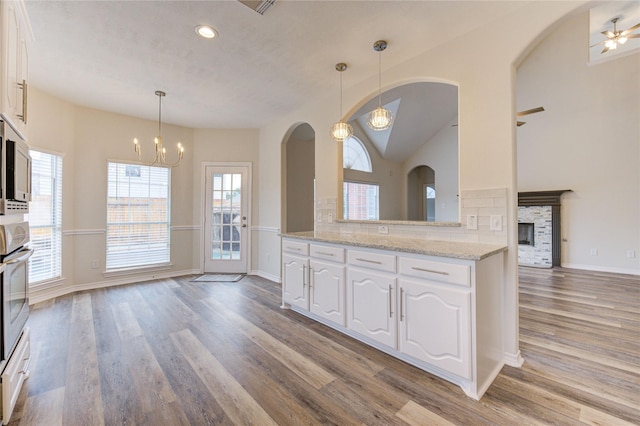 22934 Cove Timbers Ct, Tomball, TX 77375 - kitchen featuring light wood-type flooring, a chandelier, white cabinetry, vaulted ceiling, and recessed lighting