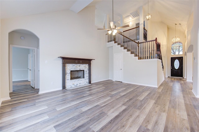 22934 Cove Timbers Ct, Tomball, TX 77375 - unfurnished living room with high vaulted ceiling, wood finished floors, ceiling fan, stairs, and a stone fireplace