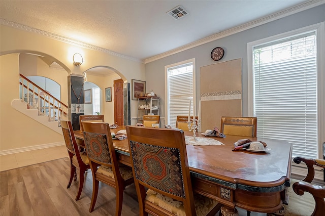1407 Ella Cir, Houston, TX 77090 - dining room featuring arched walkways, wood finished floors, stairway, crown molding, and decorative columns