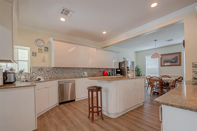 1407 Ella Cir, Houston, TX 77090 - kitchen featuring stainless steel appliances, white cabinets, decorative backsplash, recessed lighting, and beam ceiling