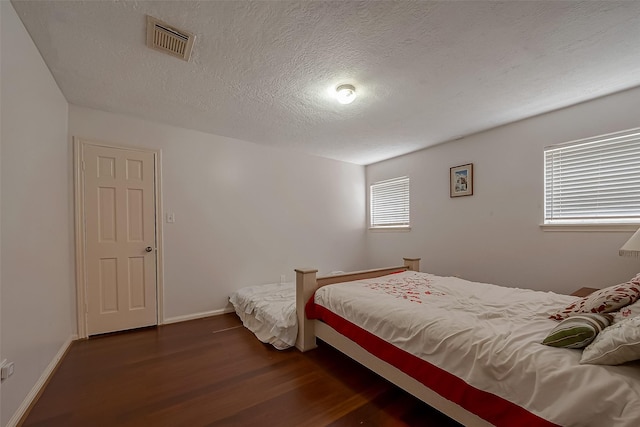 1407 Ella Cir, Houston, TX 77090 - bedroom featuring dark wood finished floors and a textured ceiling