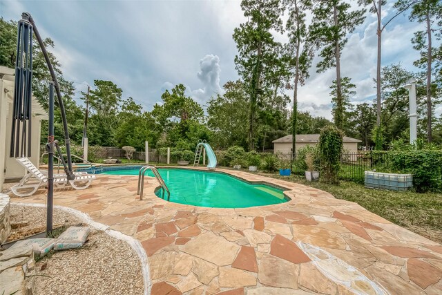 1407 Ella Cir, Houston, TX 77090 - view of pool featuring a water slide, a patio area, and view of scattered trees