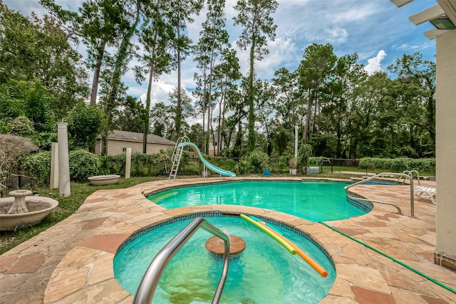 1407 Ella Cir, Houston, TX 77090 - view of swimming pool with an in-ground hot tub, a water slide, a patio, and view of wooded area