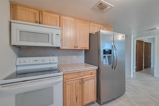 1640 Shepherd St, Hempstead, TX 77445 - kitchen with white appliances, tile countertops, backsplash, and light brown cabinets