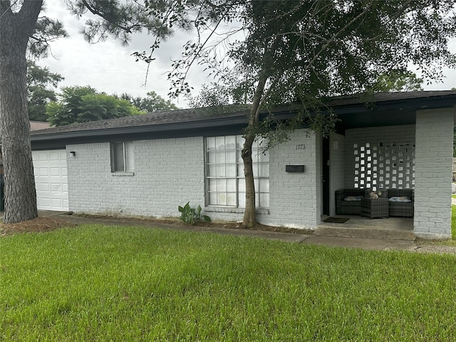 1773 El Mar Ln, Seabrook, TX 77586 - rear view of house with brick siding, a yard, roof with shingles, and a garage
