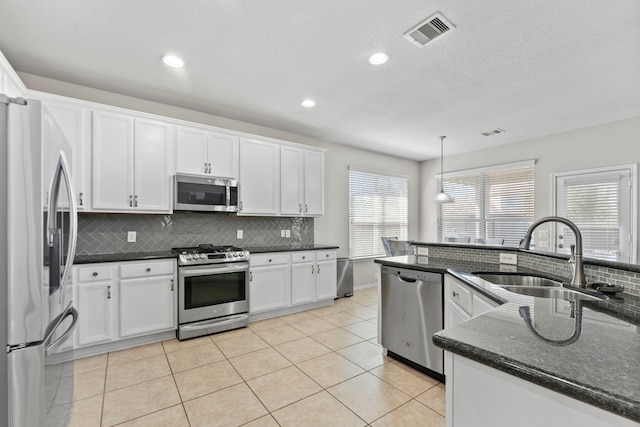 13815 Lake Livingston Dr, Houston, TX 77044 - kitchen featuring appliances with stainless steel finishes, backsplash, white cabinets, recessed lighting, and light tile patterned floors