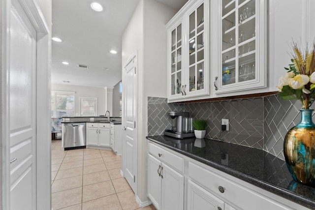13815 Lake Livingston Dr, Houston, TX 77044 - kitchen featuring stainless steel dishwasher, light tile patterned floors, tasteful backsplash, glass insert cabinets, and recessed lighting