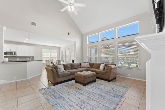 13815 Lake Livingston Dr, Houston, TX 77044 - living room with light tile patterned floors, a ceiling fan, high vaulted ceiling, and ornate columns
