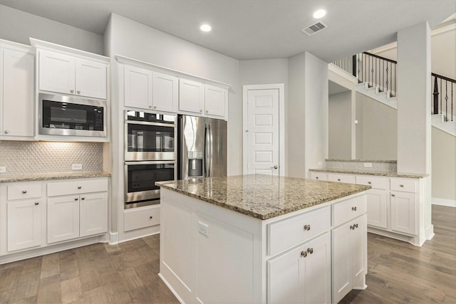 28622 Mountain Timber Ct, Fulshear, TX 77441 - kitchen with stainless steel appliances, decorative backsplash, dark wood-style flooring, white cabinets, and recessed lighting
