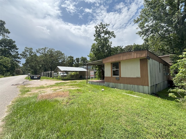 21061 Brazos Dr, New Caney, TX 77357 - view of property exterior with a lawn, driveway, and a carport