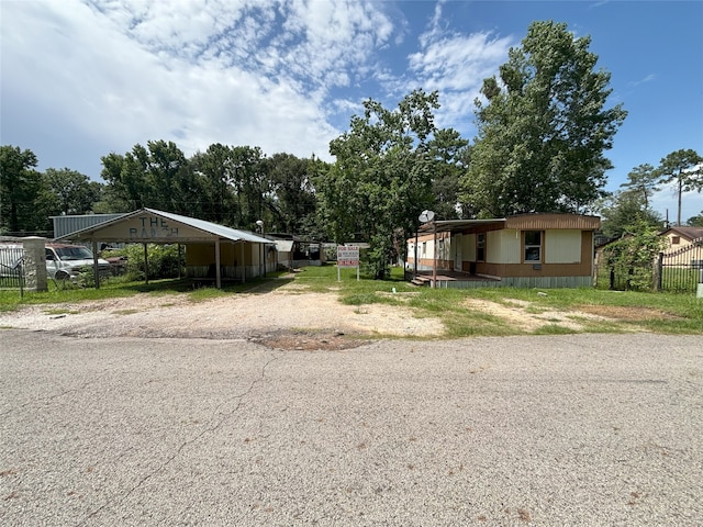 21061 Brazos Dr, New Caney, TX 77357 - manufactured / mobile home with driveway, a carport, and view of wooded area