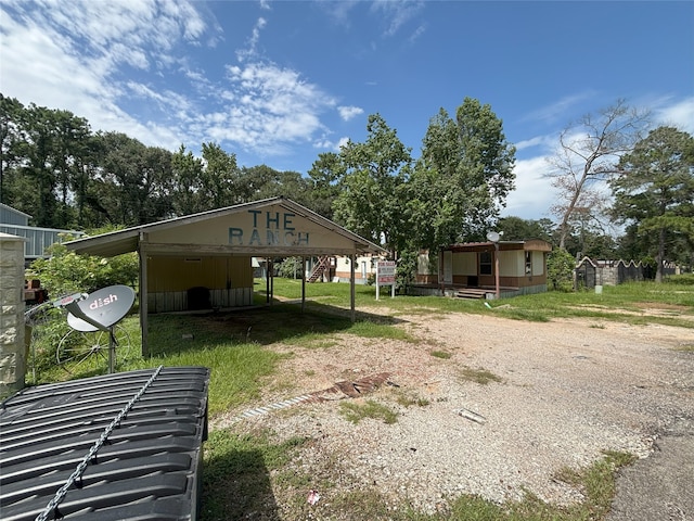 21061 Brazos Dr, New Caney, TX 77357 - view of yard featuring dirt driveway and a carport