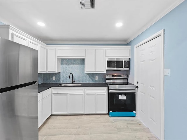 4418 Dacca Dr, Houston, TX 77047 - kitchen featuring appliances with stainless steel finishes, dark countertops, ornamental molding, white cabinets, and decorative backsplash