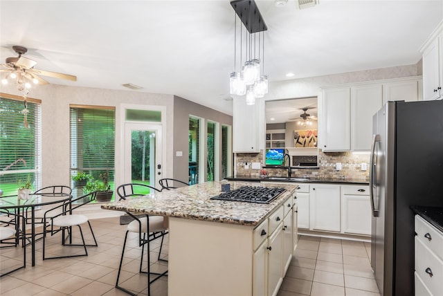 14419 Timbergreen Dr, Magnolia, TX 77355 - kitchen featuring stainless steel fridge, a ceiling fan, gas stovetop, light tile patterned flooring, and tasteful backsplash