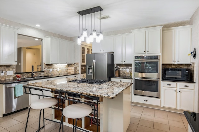 14419 Timbergreen Dr, Magnolia, TX 77355 - kitchen featuring appliances with stainless steel finishes, light tile patterned floors, a center island, decorative backsplash, and recessed lighting