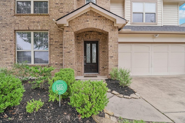 4003 Autumn Pines Trl, Houston, TX 77084 - doorway to property featuring brick siding, concrete driveway, a garage, and roof with shingles